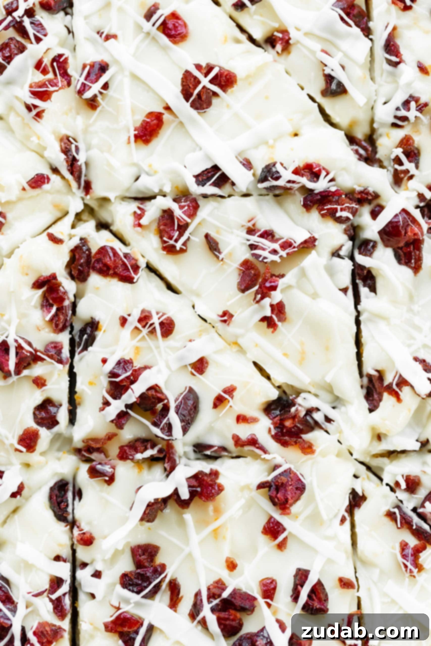 a photo of several orange cranberry bliss bars that have been cut into triangles and then stacked on top of each other so you can see the cross section of the blondies.