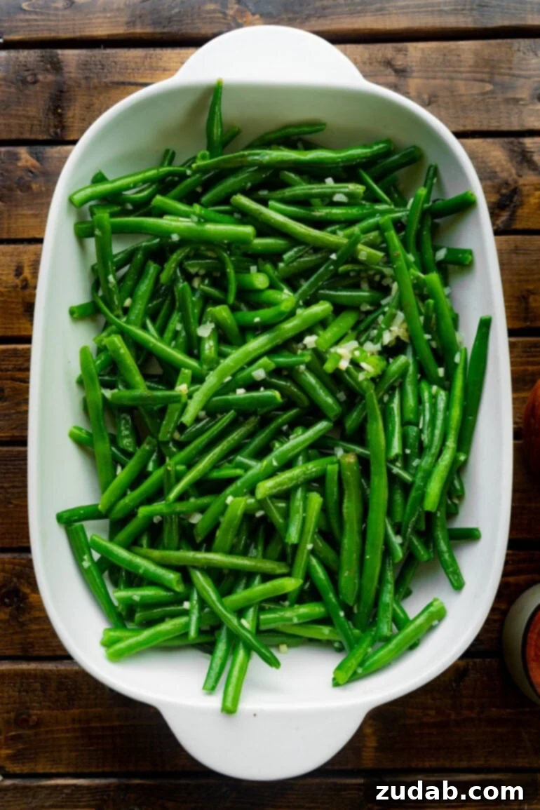 Ultimate Ranch Green Beans 3 a photo of a casserole dish full of bright green fresh green beans mixed with minced shallots.