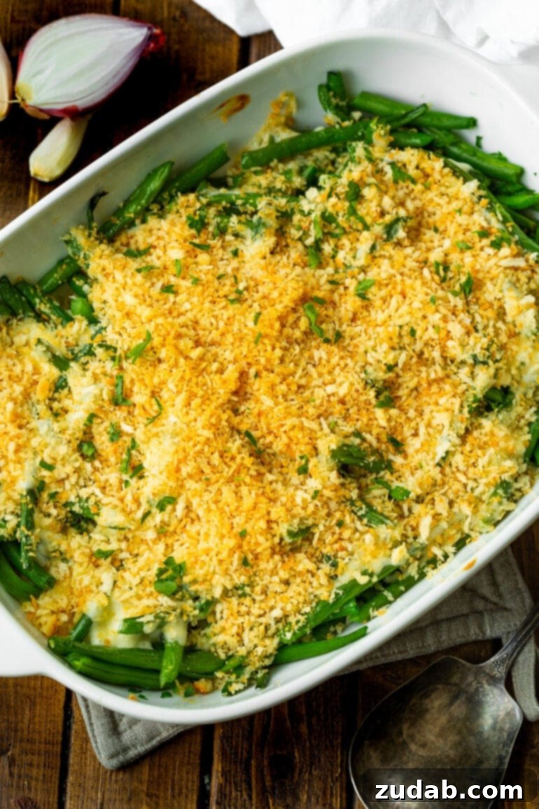 Ultimate Ranch Green Beans 4 a photo of a white casserole dish full of creamy green beans topped with a golden panko breadcrumb topping.