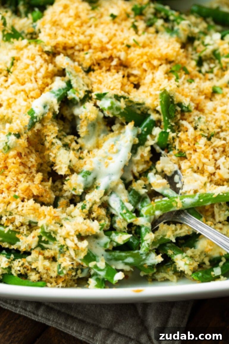 Ultimate Ranch Green Beans 5 a close up photo of green beans mixed with a creamy ranch sauce all topped with a golden crunchy panko topping.