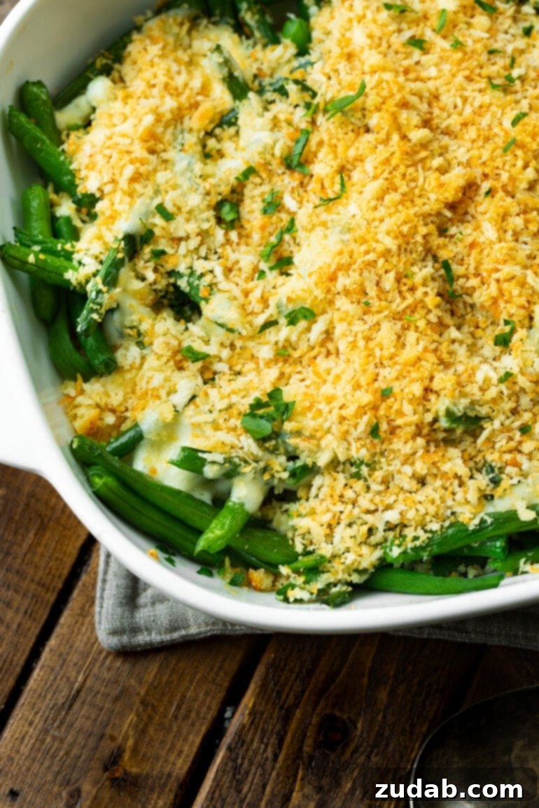 Ultimate Ranch Green Beans 6 a photo of the corner of a casserole dish full of green beans topped with a creamy ranch sauce with a crunchy golden panko topping.