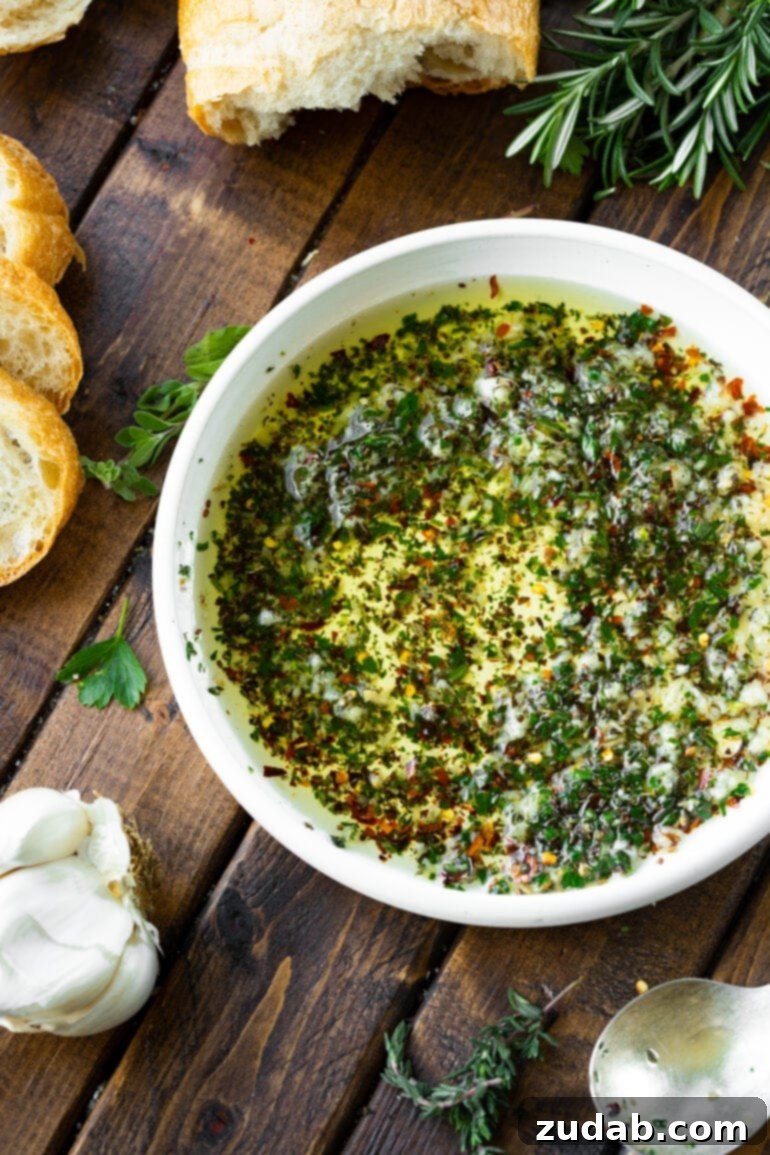 Sizzling Italian Dipping Oil for Crusty Bread 5 a photo of a shallow white bowl full of an herby Italian dipping oil.