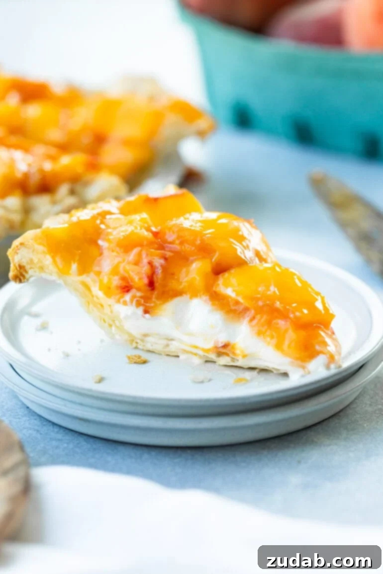 Peaches and Cream Pie Perfection 6 A close-up of a single slice of creamy peach pie on a white dessert plate, highlighting its homemade golden crust, smooth cream base, and a bountiful topping of vibrant, juicy peach slices.