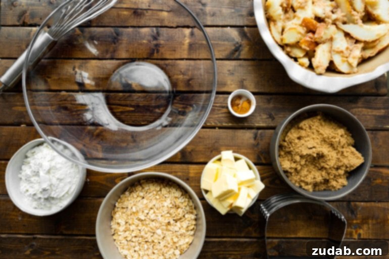 Heavenly Pear Crisp 5 A flat lay photograph showcasing all the individual ingredients for a pear crisp, meticulously arranged in separate bowls, including oats, butter, cinnamon, brown sugar, and sliced pears.