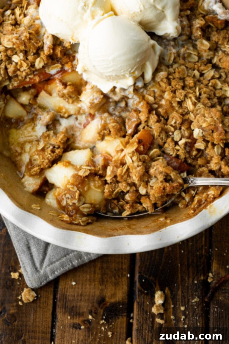 Heavenly Pear Crisp 9 A captivating photo of a hand gently scooping a luscious serving of pear crisp from a circular baking dish, highlighting its rich texture.