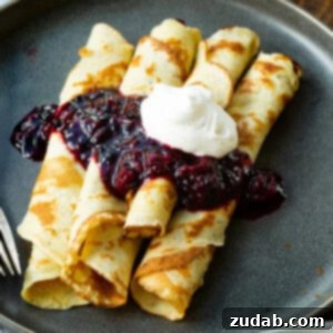 A top-down view of beautifully rolled Finnish pancakes with a rustic, home-cooked charm, ready to be served, highlighting their golden hue.