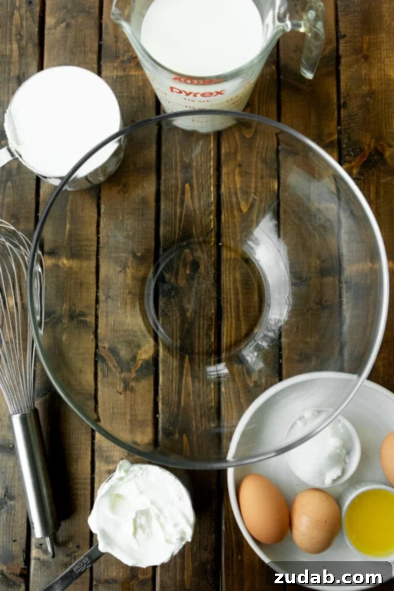 Classic Swedish Pancakes 4 A large, empty glass mixing bowl sits prominently in the center, surrounded by an array of individual small bowls, each holding a perfectly portioned ingredient ready for making Swedish pancakes. The setup suggests a clean, organized, and accessible recipe preparation.