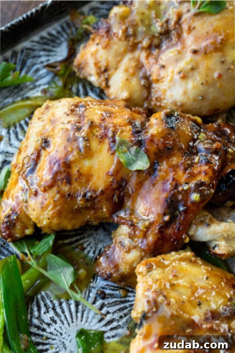 Maple Mustard Glazed Grilled Chicken Thighs 5 A vibrant photo of a single grilled chicken thigh, glistening with a rich maple mustard glaze, showcasing its mouth-watering appeal.