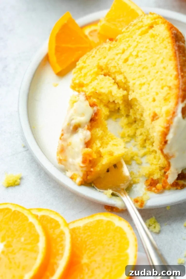 A fork poised to take a bite from a moist slice of cake, with a scattering of crumbs highlighting its deliciously tender texture.