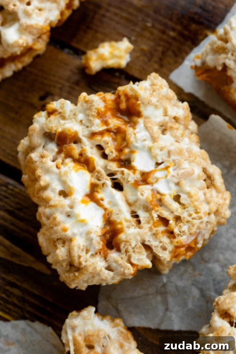 Nutty Brown Butter Caramel Krispie Delights 3 A photo of two gooey Rice Krispie Treats stuffed with dulce de leche, standing on end to display their delightful cross-sections.