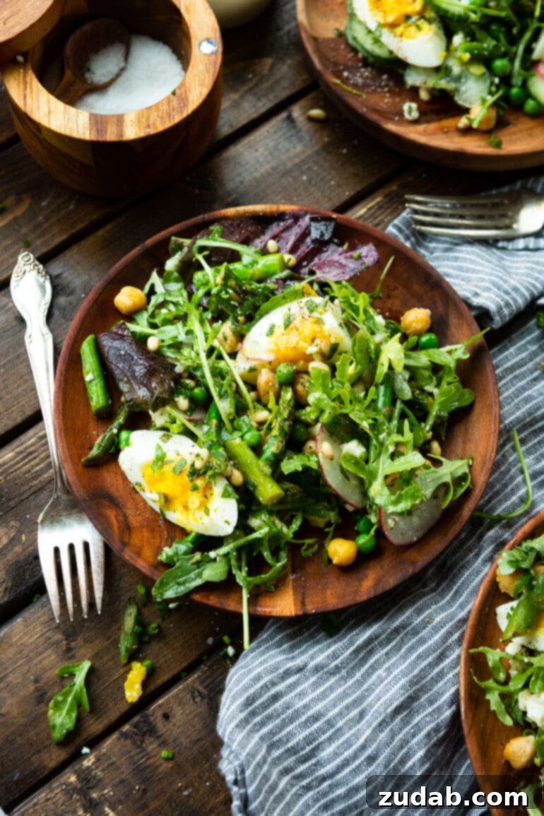 Effortless Springtime Greens 7 a photo of a wooden plate topped with a spring salad tossed in a lemon vinaigrette.