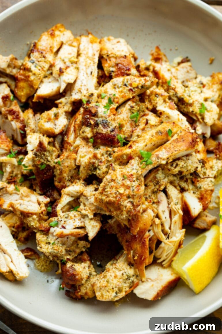 Cades Signature Chicken Gyros 5 A close-up photo of perfectly baked, sliced chicken thighs, lightly seasoned with fresh parsley. The chicken is moist and tender, ready to be piled into warm pita bread for delicious gyros.