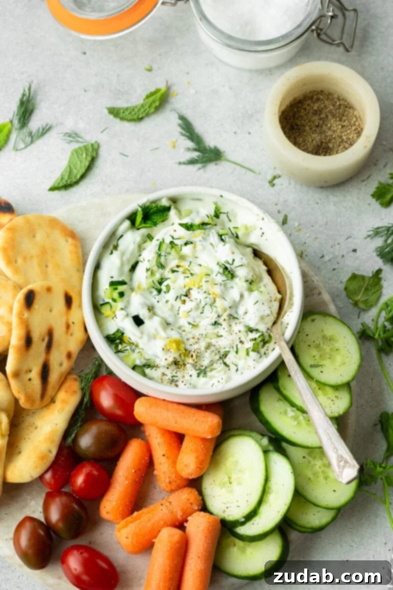The Perfect Homemade Tzatziki 3 A small bowl of homemade tzatziki sauce, garnished with fresh dill and a sprinkle of black pepper, ready to be served.