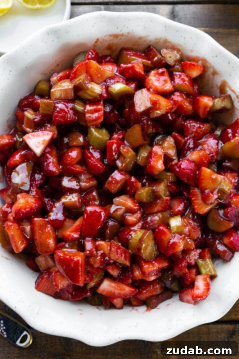 Golden Strawberry Rhubarb Crisp 3 A close-up photo showcasing fresh, vibrant strawberries and rhubarb, essential ingredients for this comforting crisp dessert.
