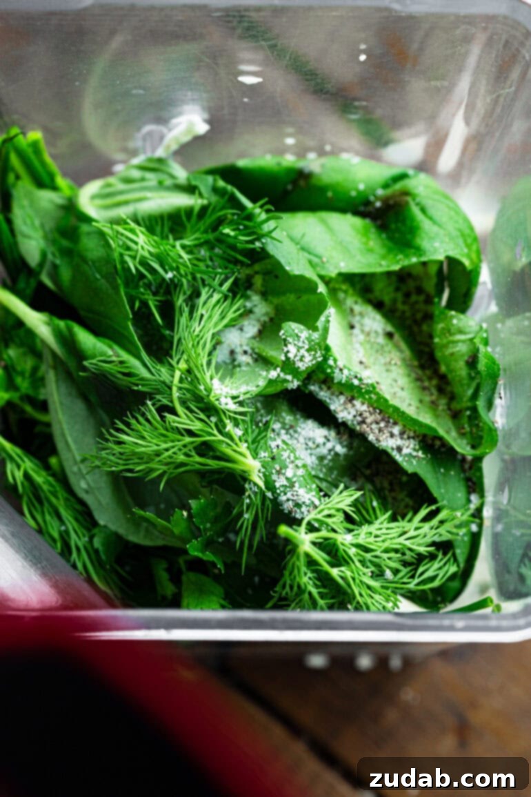 Velvety Basil Dressing Quick And Healthy 5 A top-down view of a blender filled with all the vibrant, fresh ingredients for creamy basil dressing, just moments before blending.