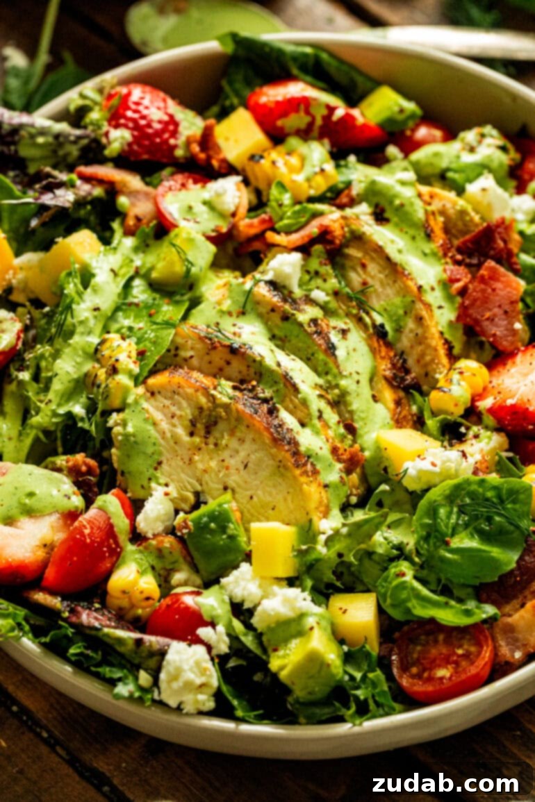 Velvety Basil Dressing Quick And Healthy 6 A vibrant summer salad topped with sliced grilled chicken breast, generously drizzled with homemade basil dressing, creating a refreshing and healthy meal.