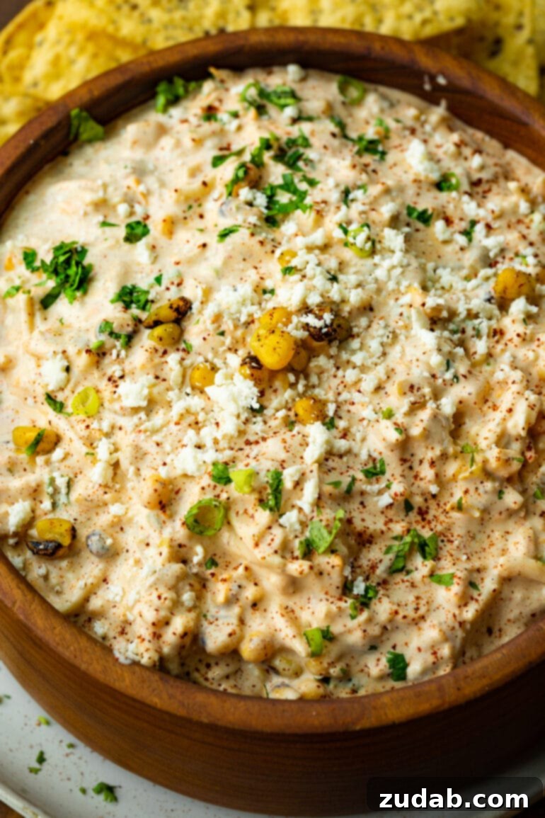 Irresistible Elote Dip 5 A beautifully presented wooden bowl filled with creamy, vibrant cold Mexican street corn dip, ready to be enjoyed as a centerpiece appetizer.
