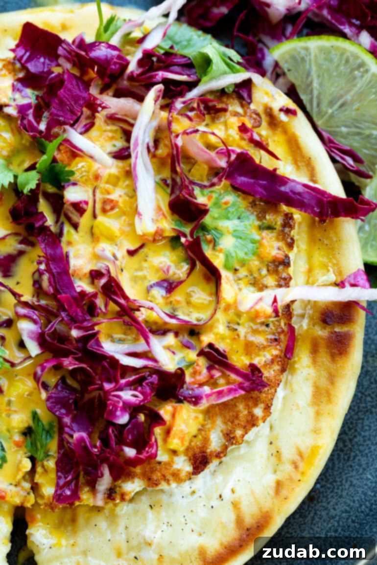 a close up photo of a coconut curry chicken burger topped with radicchio and cilantro.