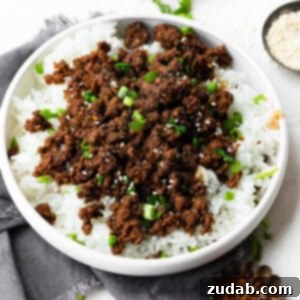 A photo of a finished bowl of Korean Ground Beef, served over rice with garnishes.