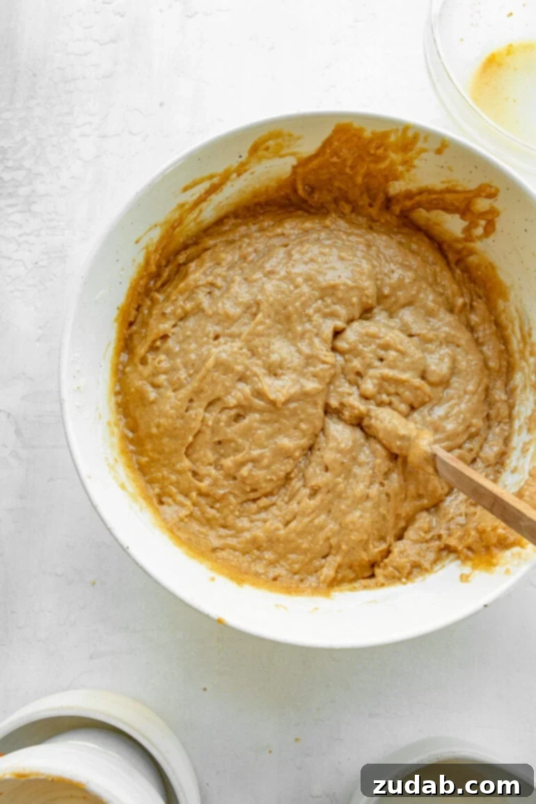 Irresistible Apple Bread with Brown Sugar Glaze 5 a photo of a bowl of the batter for apple bread with a wooden spoon stuck in it.