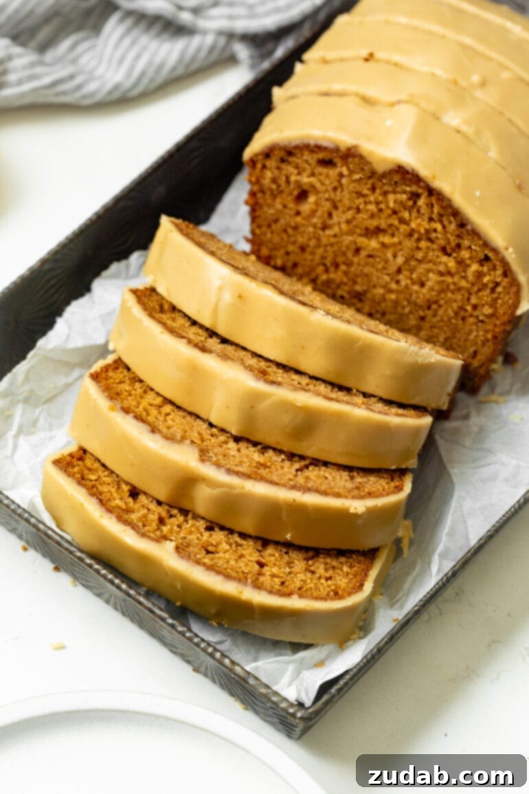 Irresistible Apple Bread with Brown Sugar Glaze 8 a photo of a loaf of apple bread topped with brown sugar icing with 4 slices removed from the loaf and leaning on each other