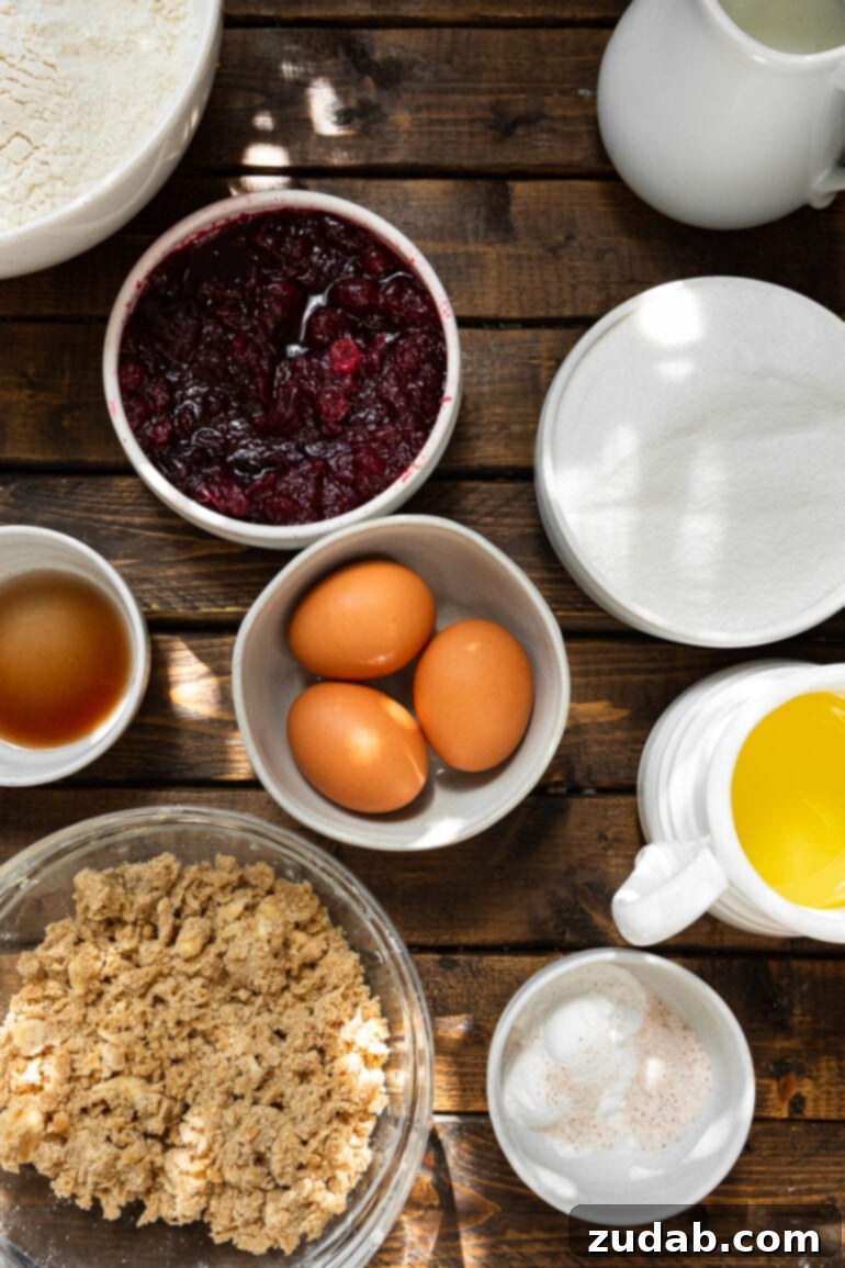 Cranberry Sauce Revival Muffins with Streusel Topping 4 A photo of all the ingredients for cranberry sauce muffins laid out in separate bowls, including butter, eggs, sugar, flour, vanilla, and cranberry sauce.
