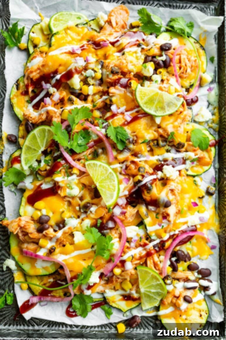 Weekly Meal Plan - September 18-24 6 A vibrant sheet pan overflowing with colorful BBQ Chicken Zucchini Nachos, loaded with melted cheese, black beans, pickled red onions, fresh chopped cilantro, grilled corn, and served with lime wedges and a drizzle of creamy dressing.