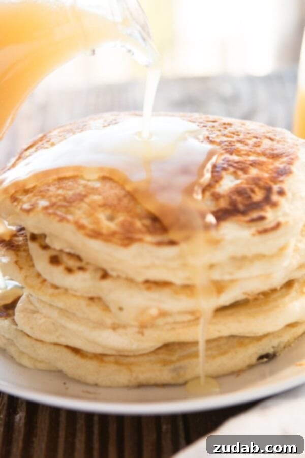 Weekly Meal Plan - September 18-24 7 A tall stack of fluffy, golden Melt-in-Your-Mouth Buttermilk Pancakes generously drizzled with rich buttermilk syrup, sitting invitingly on a white plate.