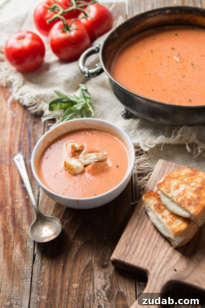 Weekly Meal Plan - September 18-24 8 A rustic bowl of rich, vibrant Roasted Tomato Basil Soup, garnished with fresh basil, and served alongside a small plate of delightful mini grilled cheese croutons, perfectly toasted and ready for dipping.