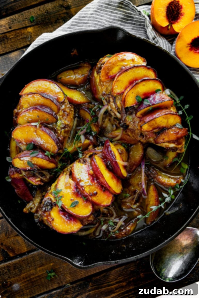 Sun-Drenched Peach Chicken 2 A large cast iron skillet filled with three golden-brown chicken breasts, each adorned with glistening sliced peaches and a rich sauce, ready to serve.