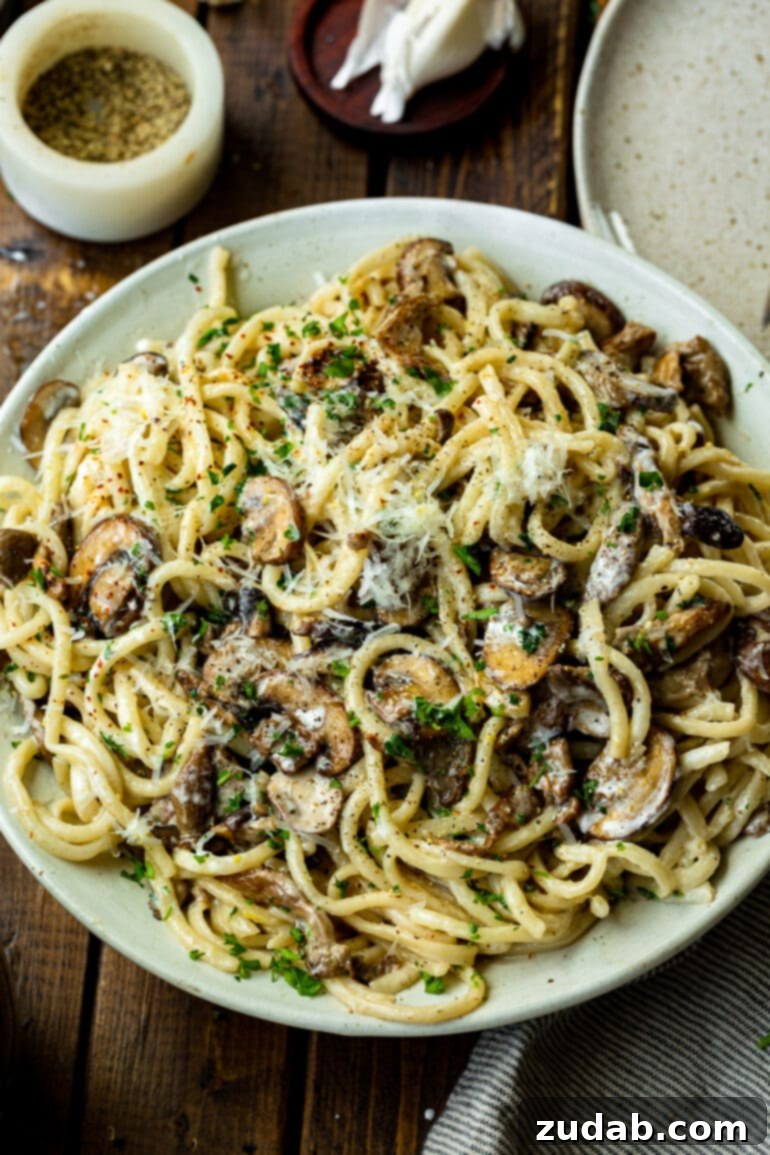 Weekly Meal Plan: October 2-8 4 A large white serving plate full of creamy pasta and caramelized mushrooms, garnished with shaved parmesan and chopped parsley for a luxurious touch.