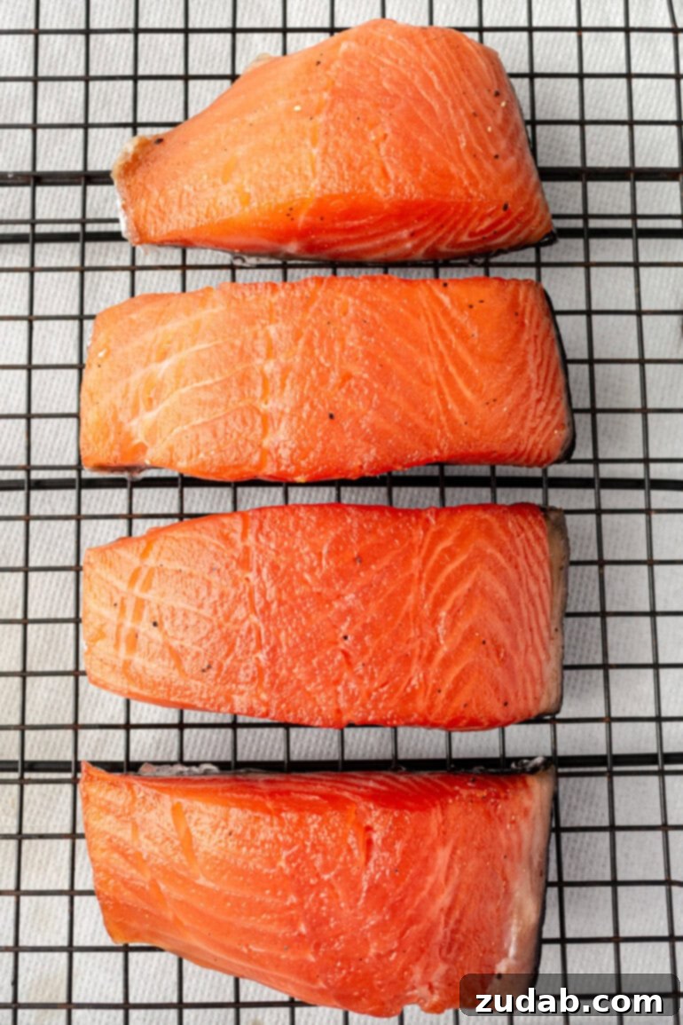 Perfect Smoked Salmon Recipe 8 Salmon fillet being generously coated with dry brine on plastic wrap