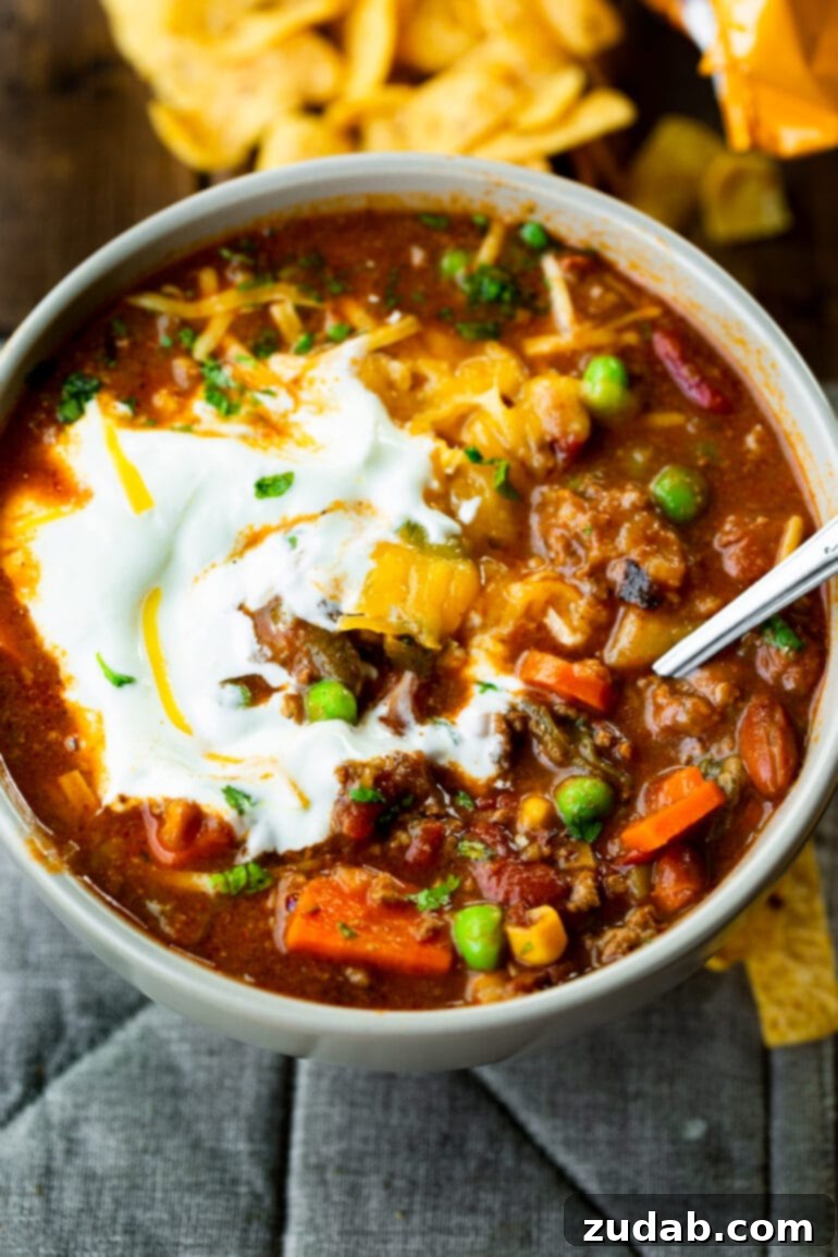 Weekly Meal Plan October 9-15 3 A close-up photo of a bowl brimming with rich taco stew, generously topped with a swirl of melting sour cream and a sprinkle of shredded cheddar cheese, ready to be enjoyed.