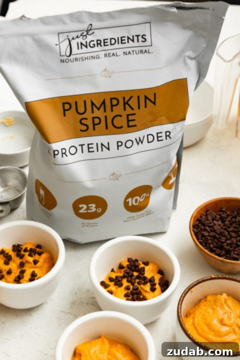 Wholesome Pumpkin Oatmeal Mug Cake 4 A bag of 'Just Ingredients' pumpkin spice protein powder sits prominently among raw pumpkin mug cake batter, emphasizing the quality and specialized flavor of the protein used.