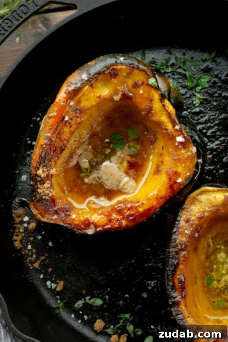 Brown Sugar Glazed Acorn Squash 3 A photo of a halved acorn squash that has been roasted until golden and caramelized with brown sugar and butter, presented beautifully.