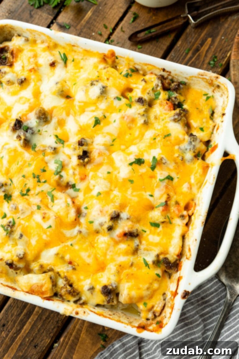 Hearty Cheesy Beef and Potato Bake 3 A top-down view of a rectangular baking dish brimming with rich hamburger potato casserole, generously topped with an irresistible layer of melted cheese.