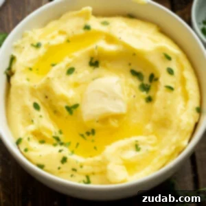 Creamy Instant Pot Mashed Potatoes 10 a photo of a bowl full of buttery mashed potatoes topped with fresh herbs and melting butter