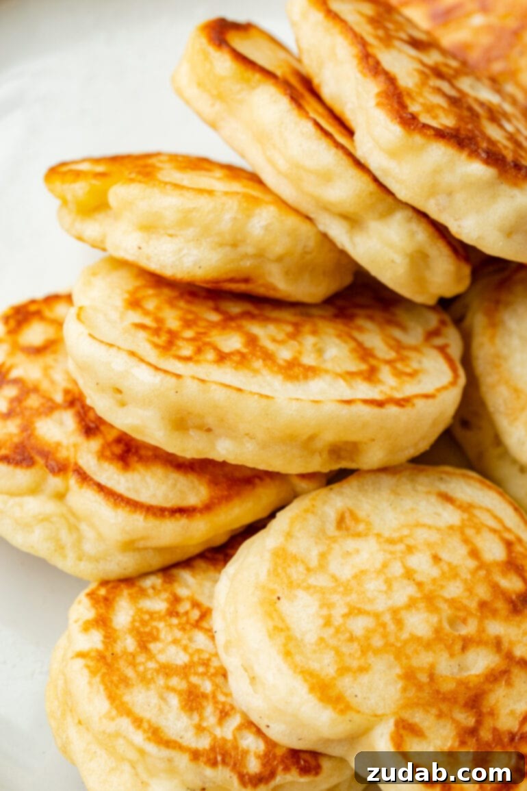 Cloud-Like Fluffy Ukrainian Oladi Pancakes 10 a photo of a stack of golden oladi pancake piled on each other and ready to serve