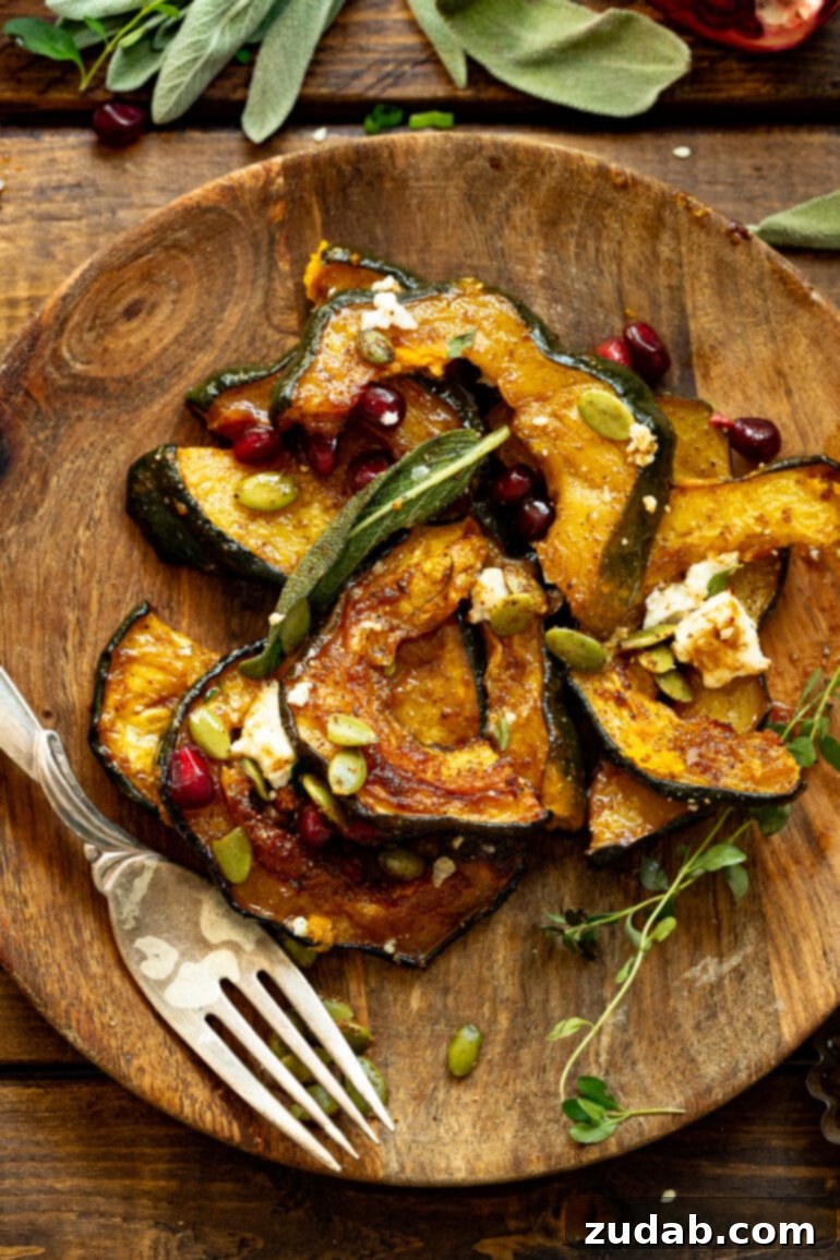 Festive Acorn Squash Delight 3 A beautifully composed photo of several golden-brown slices of roasted acorn squash resting on a rustic wooden plate, generously adorned with crumbled feta cheese, vibrant pomegranate seeds, crunchy toasted pepitas, and fragrant fried sage leaves.