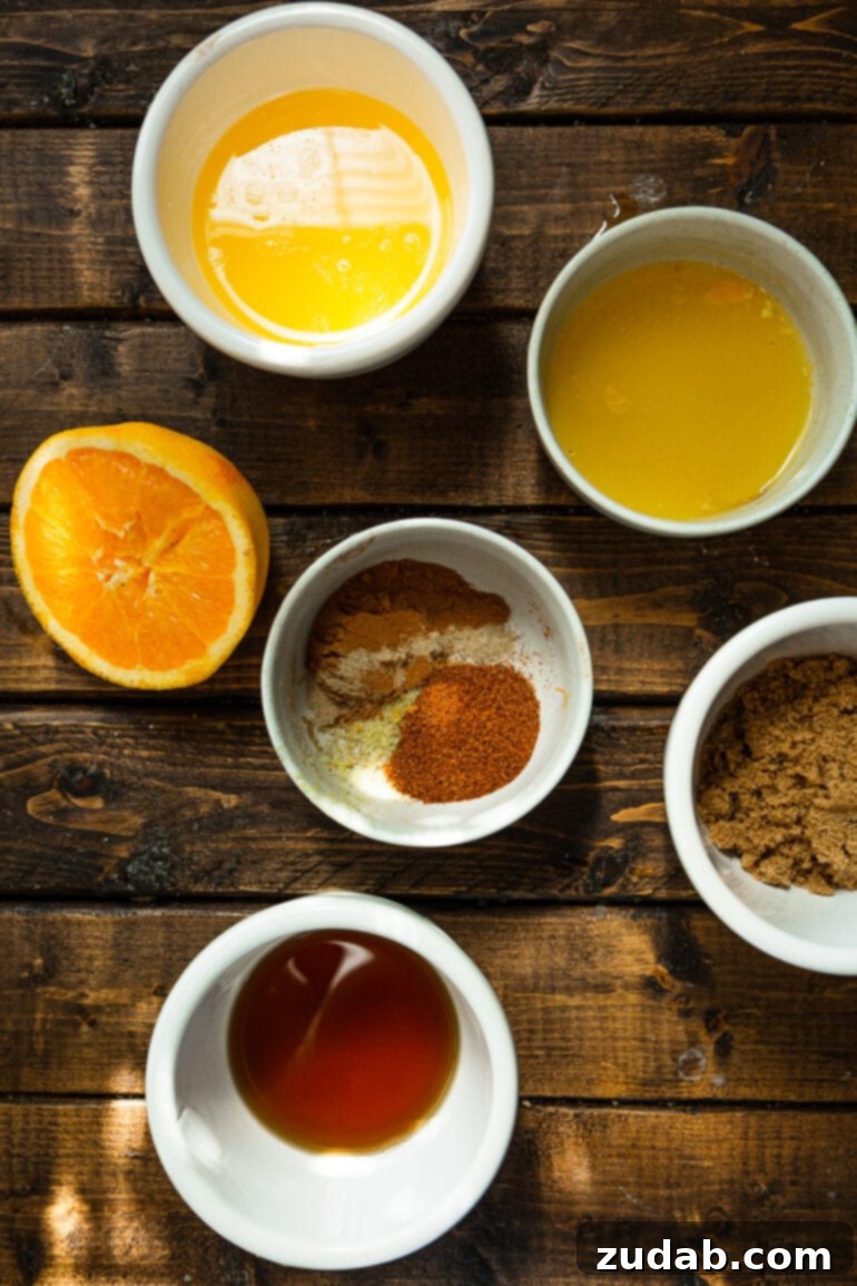 Festive Acorn Squash Delight 5 A flat lay photo showcasing a vibrant collection of small bowls filled with various holiday acorn squash seasonings, neatly arranged beside a halved fresh orange, emphasizing the aromatic spice blend.