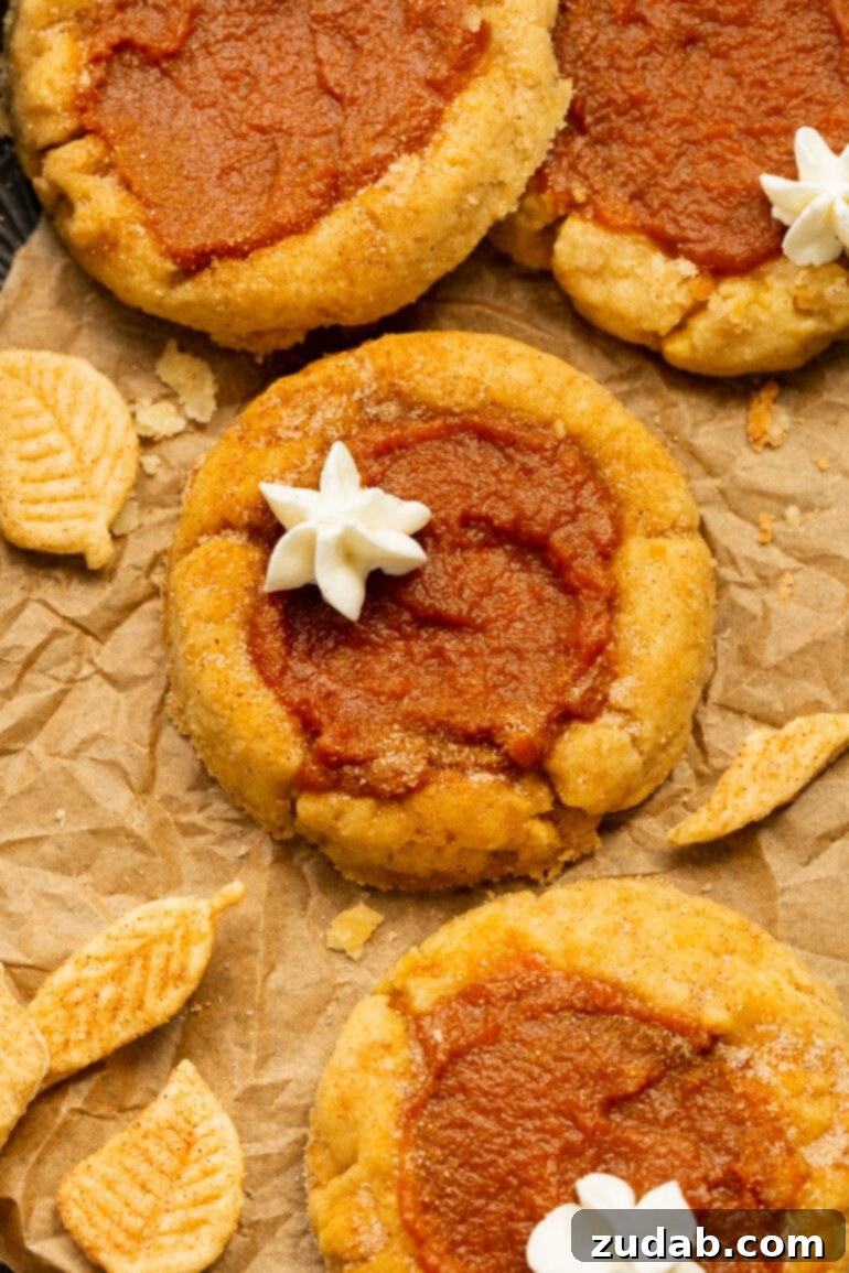Pillowy Pumpkin Pie Cookies 2 A photo of several pumpkin pie cookies topped with a little dollop of whipped cream, invitingly presented for fall.