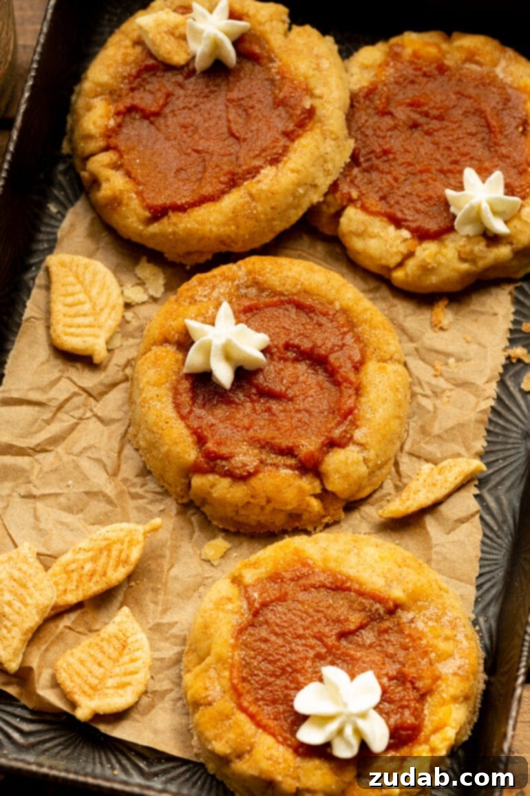 Pillowy Pumpkin Pie Cookies 5 A photo of several pumpkin pie cookies, perfectly baked and cooling on a crumpled piece of brown parchment paper.