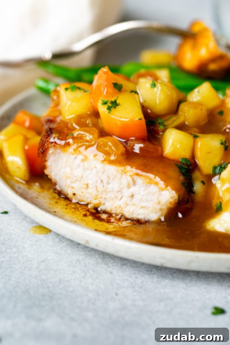 Weekly Menu Plan - Nov. 13 to 19 9 A perfectly cooked, juicy pork chop, cut open to reveal its tender interior, beautifully topped with a glistening, homemade apple chutney, presented on a plate.