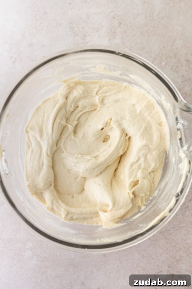 Velvet Pumpkin Chocolate Chip Bliss 9 a photo taken over the top a large glass bowl of cream cheese frosting