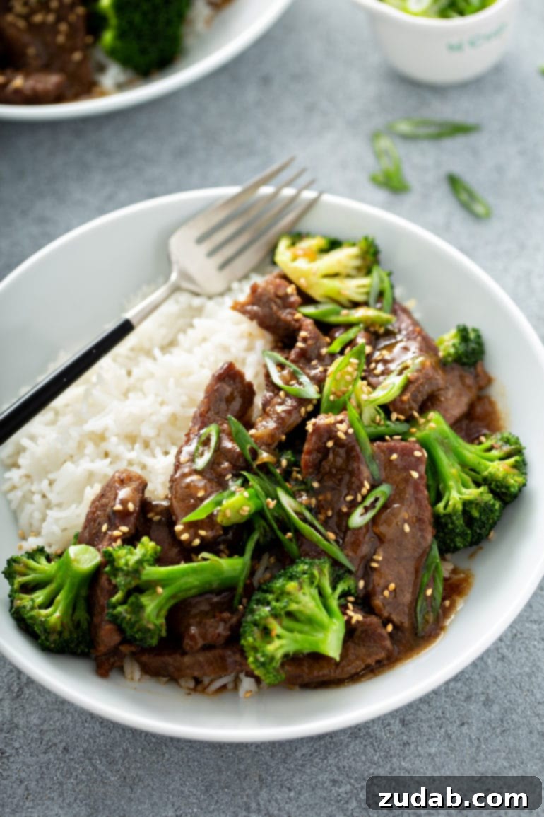 Weekly Meal Plan: November 20-26 8 A ceramic bowl filled with fluffy white rice, topped generously with tender Instant Pot beef and vibrant green broccoli, with a fork poised for enjoyment.
