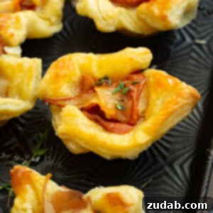 a photo of several puff pastry bite filled with roasted pear, prosciutto, thyme and hot honey
