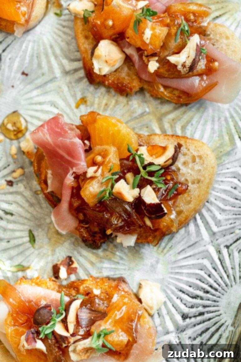 Golden Mandarin Prosciutto Bites 2 A top-down photo of vibrant mandarin orange and prosciutto crostini, artfully garnished with toasted hazelnuts and fresh thyme sprigs.