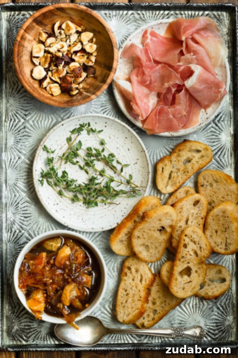 Golden Mandarin Prosciutto Bites 3 A silver platter adorned with all the fresh ingredients for mandarin and prosciutto crostinis, ready for preparation.