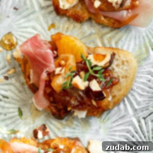Golden Mandarin Prosciutto Bites 8 A top-down photo of a mandarin orange and prosciutto crostini topped with toasted hazelnuts and fresh thyme
