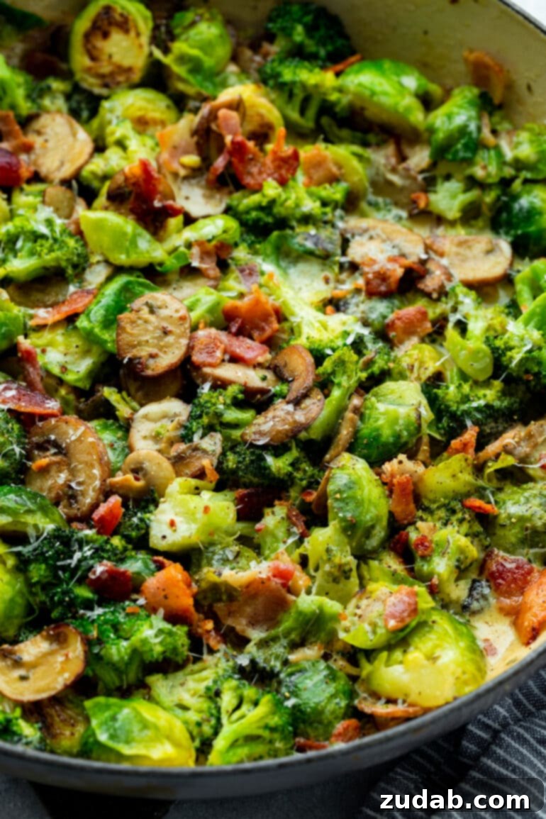 Luscious Garlic Parmesan Broccoli and Sprouts 2 A vibrant photo of creamy Brussels sprouts and broccoli, speckled with golden sautéed mushrooms and crunchy bacon, ready to be served from a skillet.